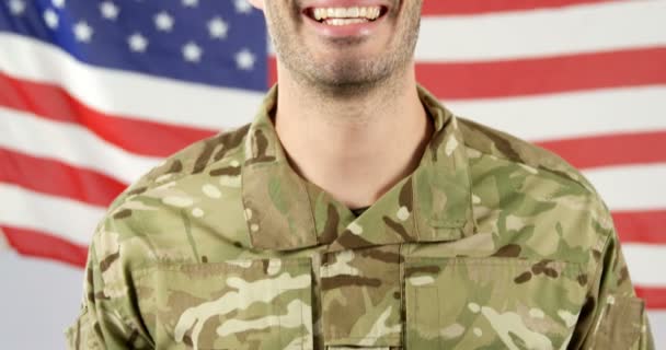 Солдат стоит перед американским флагом — стоковое видео