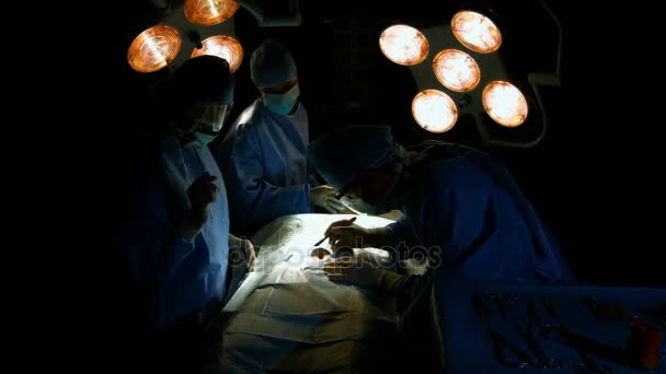 Cirujanos realizando operaciones en quirófano — Vídeos de Stock