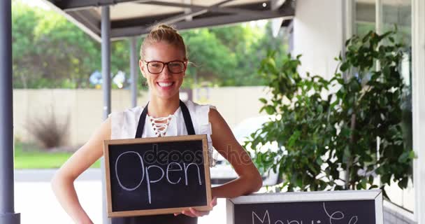 Waitress holding a chalkboard with open sign — Stock Video
