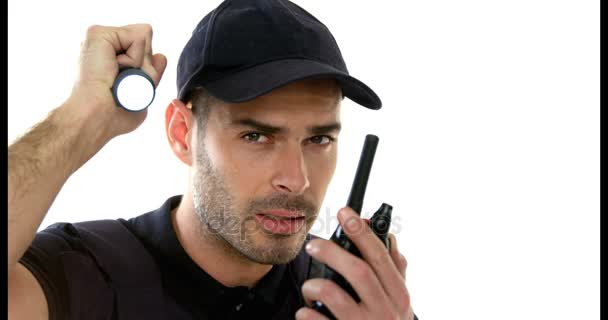 Segurança segurando tocha enquanto fala em walkie talkie — Vídeo de Stock