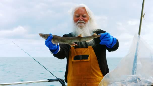 Pescador sosteniendo pescado — Vídeo de stock
