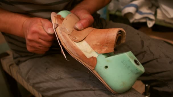 Schoenmaker snijden een stukje leer op schoen laatst — Stockvideo