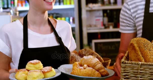 Σερβιτόρος και σερβιτόρα κρατώντας αρτοσκευάσματα — Αρχείο Βίντεο