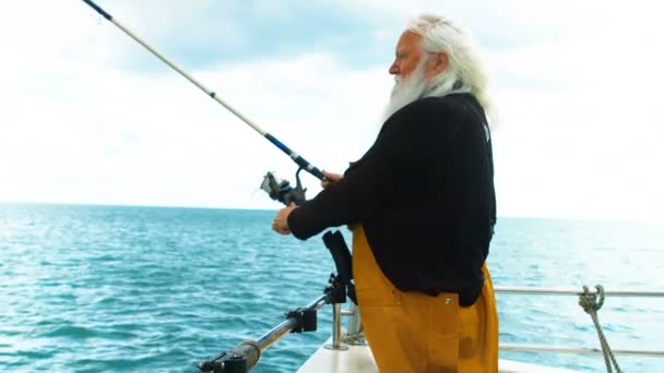 Рыбак рыбачит с лодки — стоковое видео