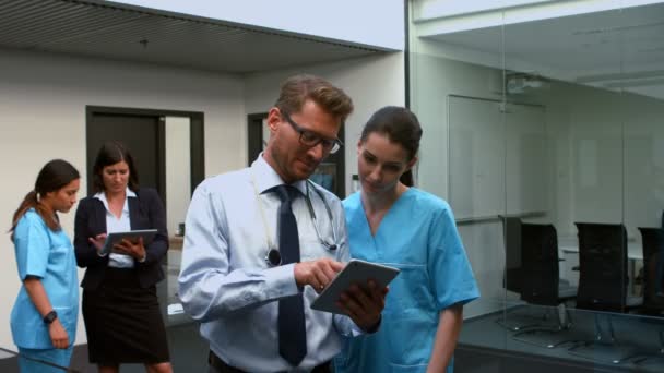 Médicos discutiendo sobre tableta digital — Vídeo de stock