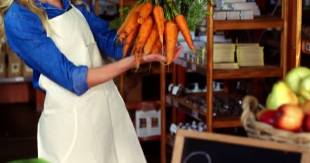 Mujer sosteniendo racimo de zanahorias — Vídeo de stock