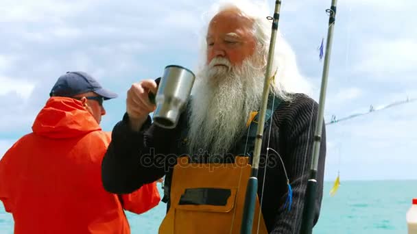Рыбак пьет чашку кофе — стоковое видео