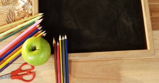 Pizarra con lápices de colores y manzana — Vídeos de Stock