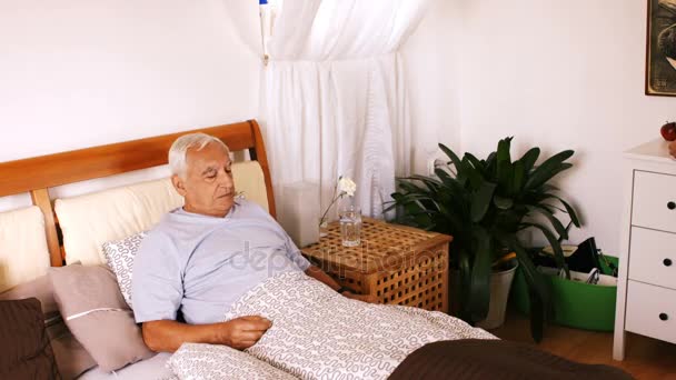 Enfermera que sirve el desayuno al hombre mayor en el dormitorio — Vídeos de Stock
