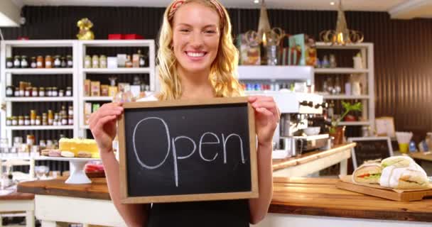 Smiling waitress showing chalkboard — Stock Video