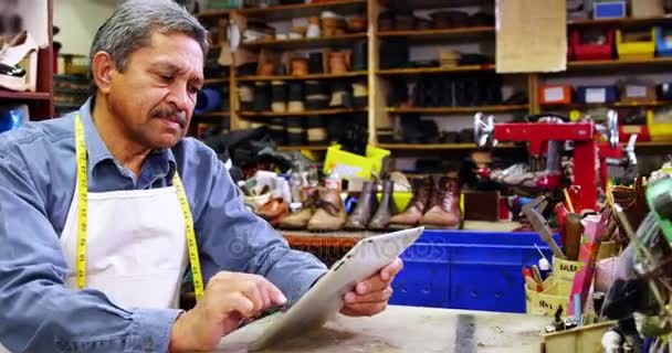 Shoemaker using digital tablet — Stock Video