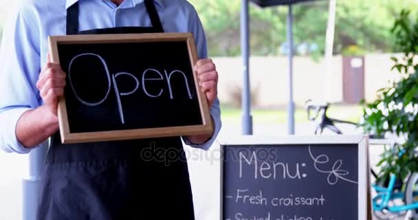 Kellner zeigt Tafel mit offenem Schild — Stockvideo