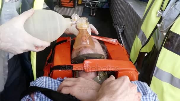 Парамедик с помощью внешнего дефибриллятора — стоковое видео