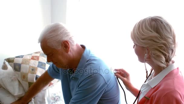 Female doctor examining senior man — Stock Video