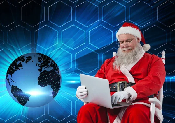 Santa sedí na židli a pomocí přenosného počítače — Stock fotografie