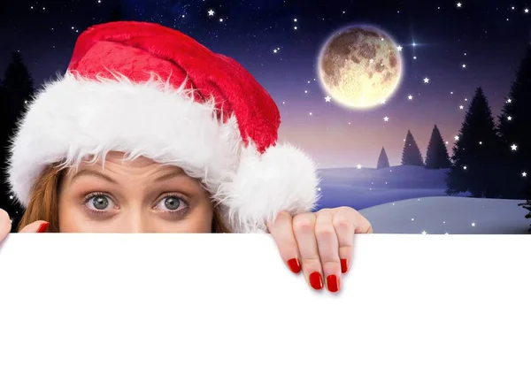 Vrouw in santa hat gluren over witte kaart — Stockfoto