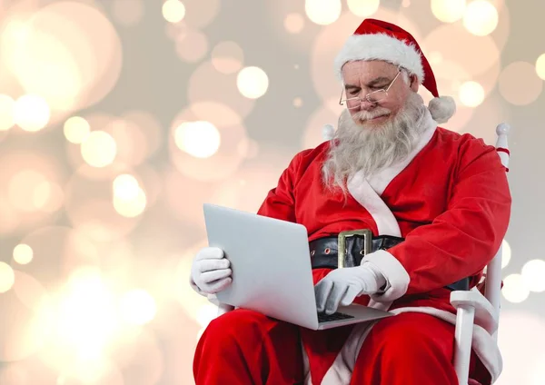 Weihnachtsmann auf Stuhl und Laptop — Stockfoto