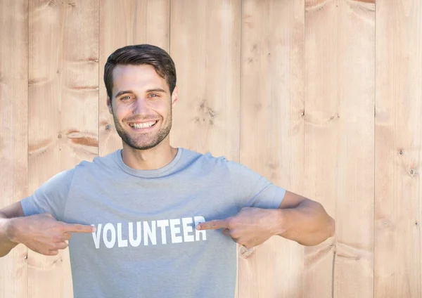 Człowiek, wskazując na tytuł wolontariusza na jego tshirt — Zdjęcie stockowe