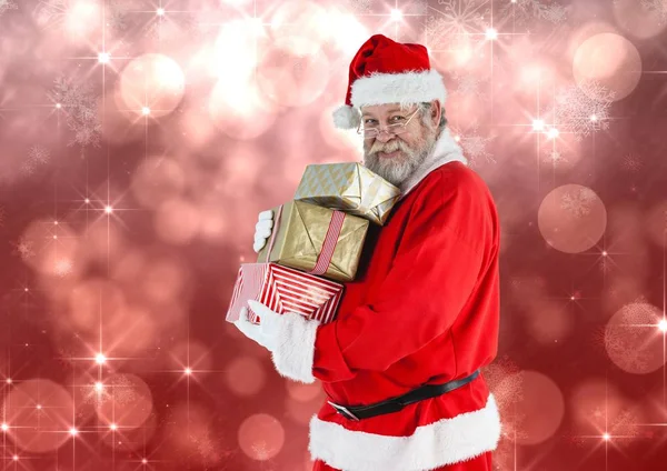 Santa claus holding stack of christmas gifts — Stock Photo, Image