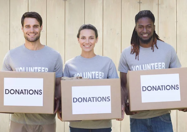 Три волонтера с коробками для пожертвований — стоковое фото