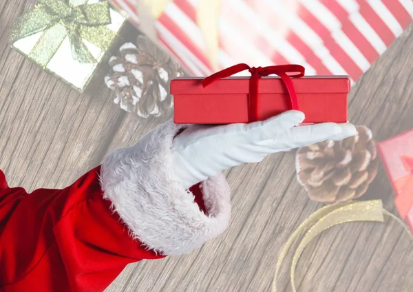 Rukou santa Claus drží vánoční dárek — Stock fotografie