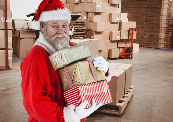 Santa claus holding stack of christmas gifts — Stock Photo, Image
