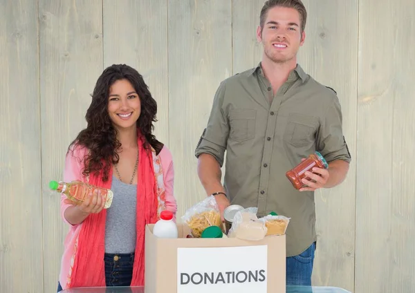 Casal segurando comestíveis de caixa de doações — Fotografia de Stock