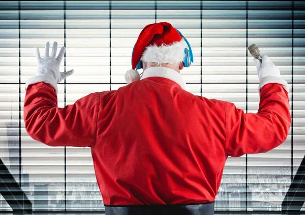 Papai Noel ouvindo fones de ouvido contra janela — Fotografia de Stock