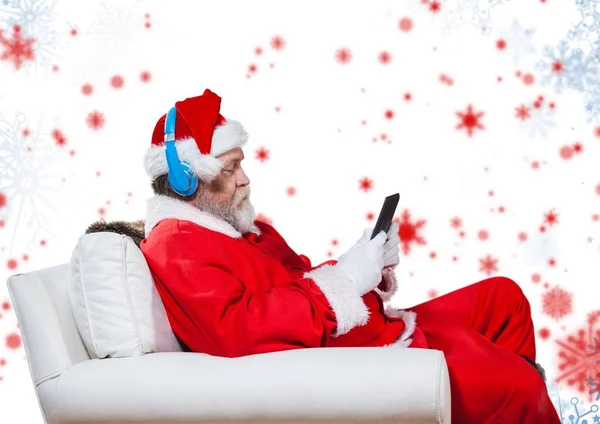 Weihnachtsmann hört Kopfhörer und nutzt Tablet — Stockfoto