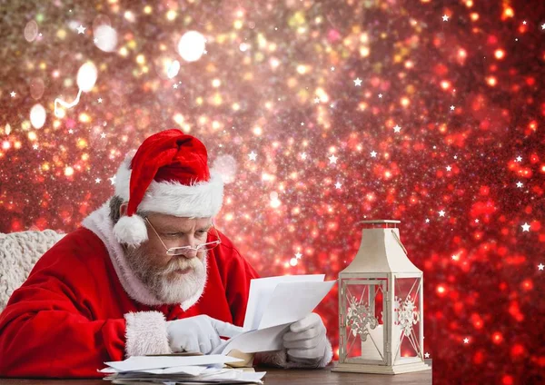 Santa en la mesa y leyendo la carta de Navidad — Foto de Stock