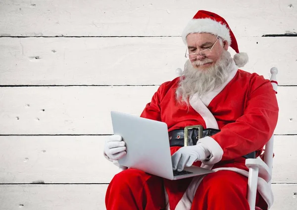 Santa sentado na cadeira e usando laptop — Fotografia de Stock