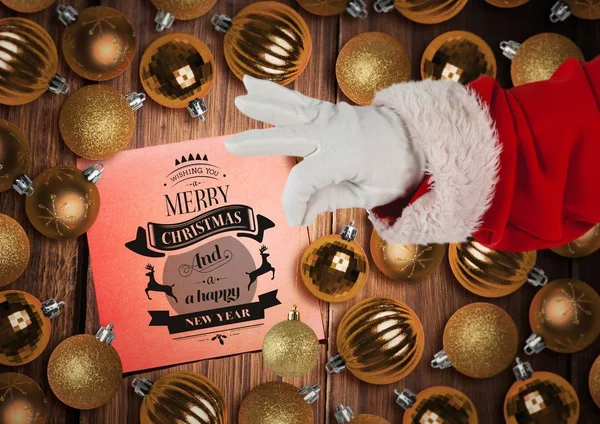Santa Claus sosteniendo bauble con saludo de Navidad —  Fotos de Stock