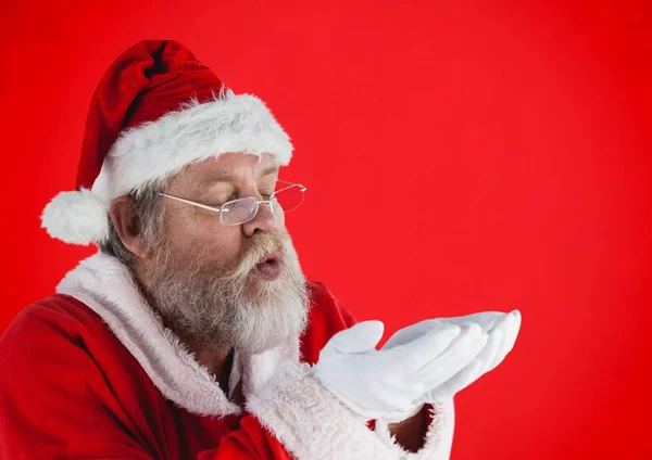 Weihnachtsmann gibt vor, imaginären Schnee zu pusten — Stockfoto