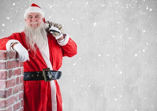 Santa med gåva säck bredvid skorsten — Stockfoto