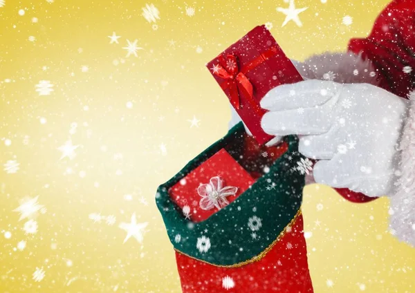 Санта кладет подарки в рождественский чулок — стоковое фото