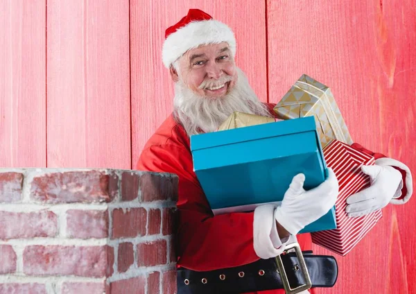 Улыбающийся Санта Клаус держит подарочные коробки — стоковое фото