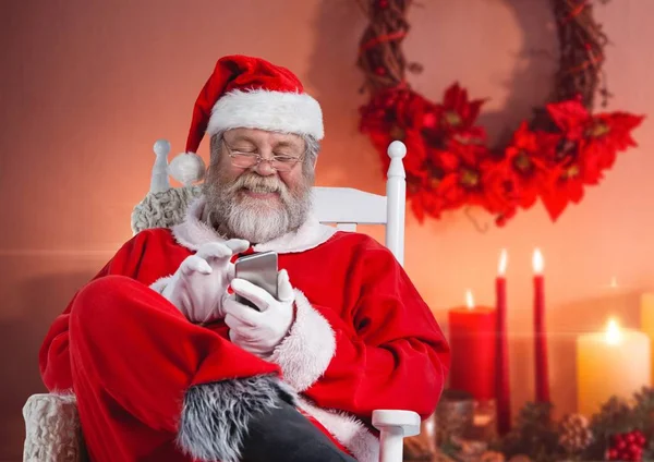 Santa sentado na cadeira e usando o telefone — Fotografia de Stock