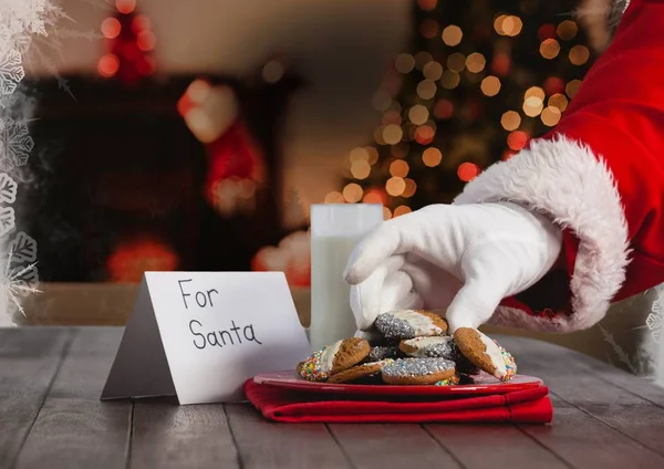 Papai Noel colocando biscoitos de Natal na mesa — Fotografia de Stock