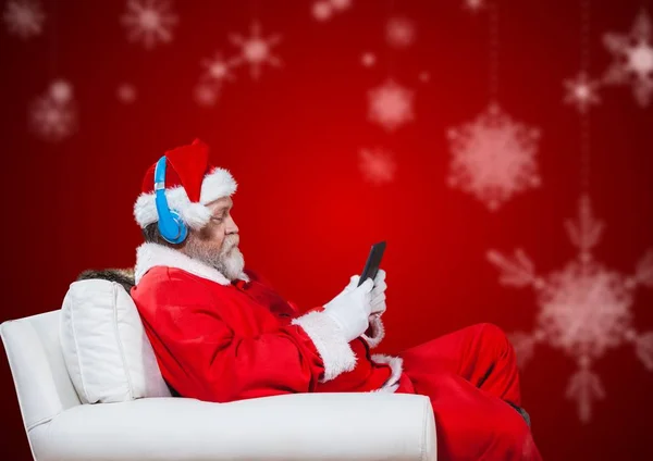 Père Noël sur chaise et en utilisant le téléphone — Photo