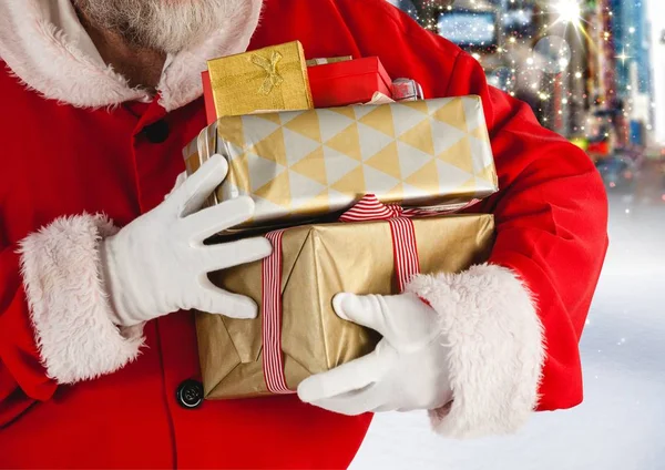 Santa claus holding stack of christmas gifts — Stock Photo, Image