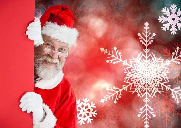 Santa claus pokukování z červené stěny — Stock fotografie