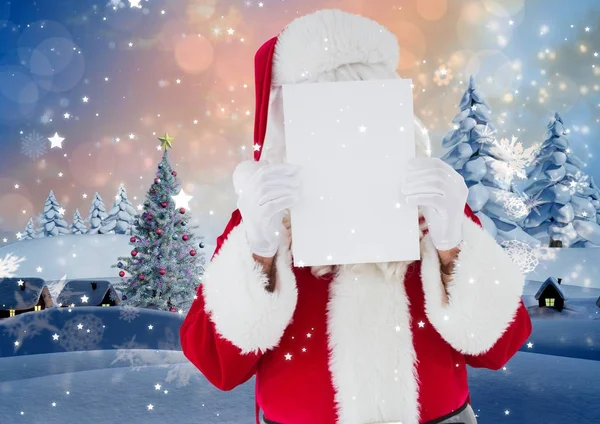 Papai Noel segurando papel branco na frente de seu rosto — Fotografia de Stock