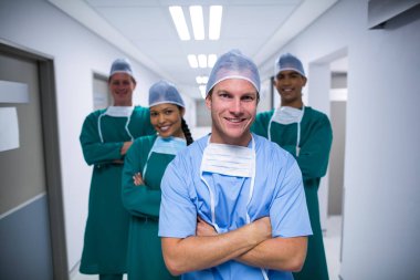 nurse and surgeons standing in corridor clipart