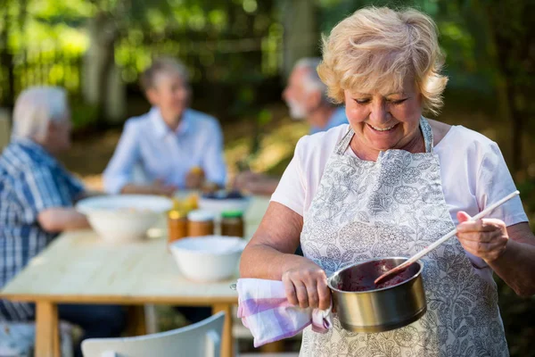 Seniorin bereitet Marmelade zu — Stockfoto