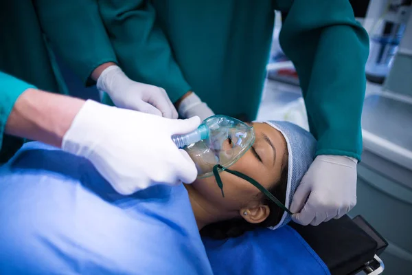 Cirurgiões ajustando máscara de oxigênio na boca do paciente — Fotografia de Stock