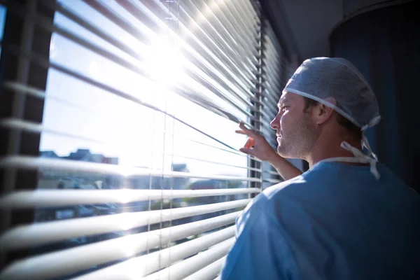 Arzt schaut durch Fenster — Stockfoto