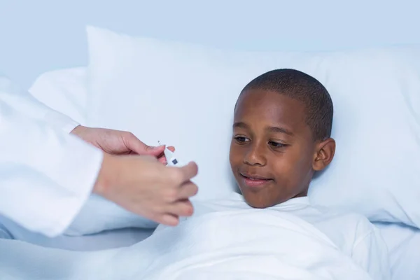 Doctor checking fever from digital thermometer — Stock Photo, Image