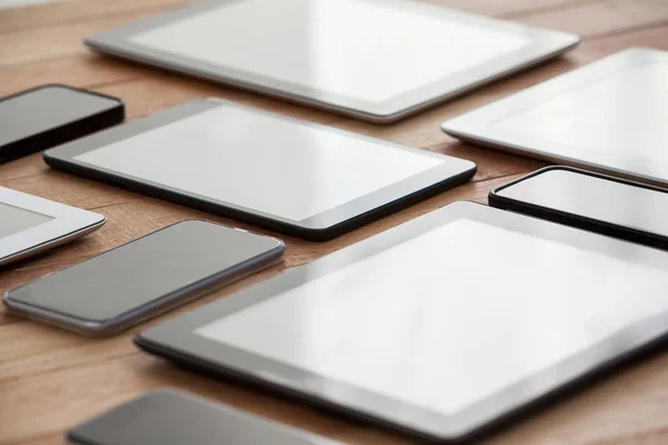 Mobiele telefoons en digitale tabletten op tafel — Stockfoto