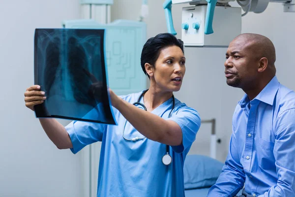 Медсестра обсуждает рентген с пациентом — стоковое фото
