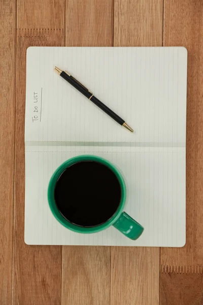Tasse à café avec journal et stylo — Photo